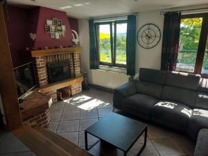 a living room with a couch and a fireplace at L'Éphém'Heer in Hastière-par-delà