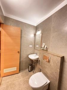 a bathroom with a white toilet and a sink at Gopuram Grand in Madurai