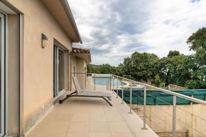 a balcony with a bench on the side of a house at Villa Gecko avec piscine in Sari Solenzara