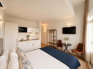 a hotel room with a bed and a kitchen at Ribeira Porto by MyStay - Self Check-in Hotel in Porto