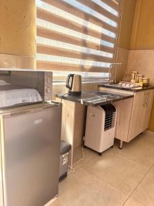 a kitchen with a refrigerator and a table with a microwave at Ring Road Guesthouse in Vereeniging
