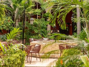 a garden with chairs and trees and a fountain at Sofitel Legend Santa Clara Cartagena in Cartagena de Indias