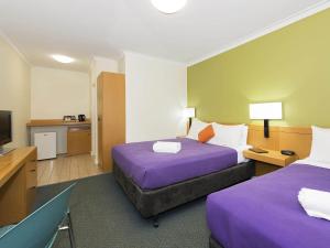 a hotel room with two beds and a flat screen tv at ibis Styles Geraldton in Geraldton