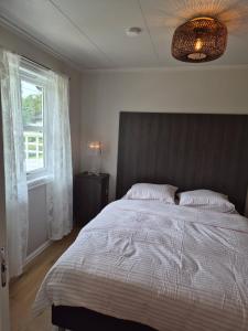 a bedroom with a large bed and a window at Garden House 1 in Hvaler +11 photos