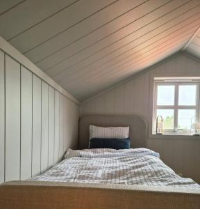 a bed in a room with a roof at Garden House 1 in Hvaler