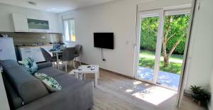 a living room with a couch and a kitchen at Cherry Garden Apartment in Podgorica
