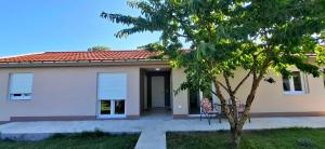 a house with a tree in front of it at Cherry Garden Apartment in Podgorica