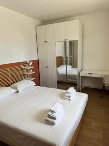 a bedroom with a large white bed with towels on it at Almaré Luxury Beach Apartments in Taranto