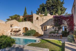 an external view of a house with a swimming pool at Kapsaliana Village Hotel in Kapsalianá
