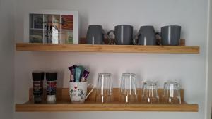 a shelf with glasses and cups on it at Apartmán C311 in Frymburk