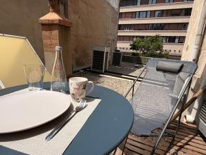 a table with plates and a bottle on a balcony at Studio Américain Haut de Gamme in Toulon