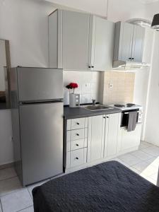 a white kitchen with a refrigerator and a sink at Jenny's Holiday Villas in Polychrono