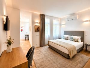 a bedroom with a bed and a table and a desk at Ribeira Porto by MyStay - Self Check-in Hotel in Porto