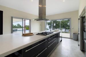 a kitchen with white countertops and a stove top oven at Villa Gecko avec piscine in Sari Solenzara