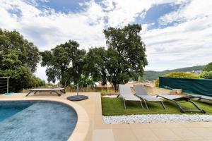 a swimming pool with two chairs and a table and a picnic table at Villa Gecko avec piscine in Sari Solenzara