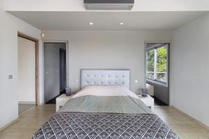 a bedroom with a large bed and a large window at Villa Gecko avec piscine in Sari Solenzara +37 photos