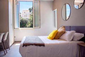 a bedroom with a bed with pillows and a mirror at My Residence d'Azur in Beausoleil