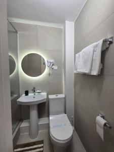 a bathroom with a toilet and a sink and a mirror at Aktobe Hotel in Aktobe