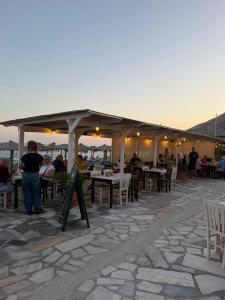 a group of people sitting at tables in a restaurant at Myrtos Hidden Garden Villa in Ierapetra