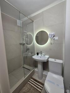 a bathroom with a shower and a toilet and a sink at Aktobe Hotel in Aktobe
