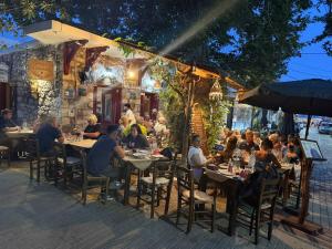 a group of people sitting at tables outside a restaurant at Myrtos Hidden Garden Villa in Ierapetra