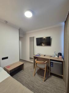 a hotel room with a desk and a bed at Aktobe Hotel in Aktobe