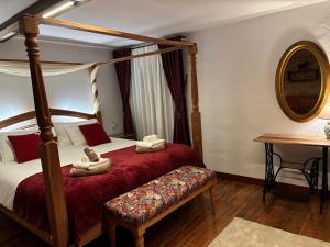 a bedroom with a four poster bed and a table at Villa Lajares Red House Fuerteventura in Lajares