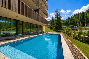 a swimming pool in front of a building at Alma Alpina Lodge, Adults Only in Obereggen