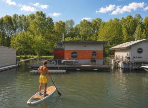 a man on a paddle board in the water at Sunset view Housboat with sundeck,AC&Heating in Bratislava +44 photos
