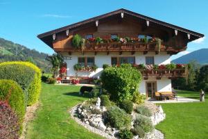 a house with a balcony with flowers on it at Apart Lisi in Fügenberg