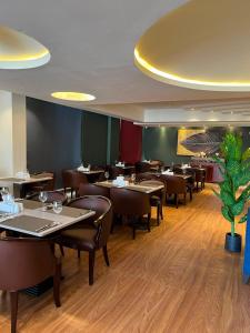 a dining room with tables and chairs in a restaurant at Saffron Hotel and Lounges in Muscat