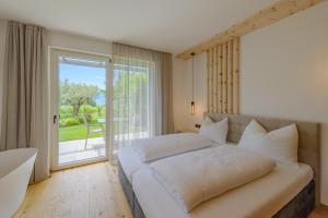 a bedroom with a large bed and a sliding glass door at Kardonighof Kaltern in Caldaro +64 photos