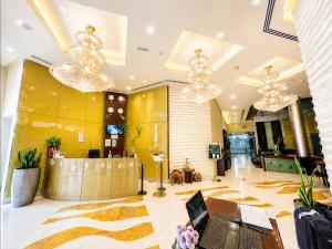 a lobby with chandeliers and a laptop on a desk at Tulip Creek Hotel Apartments in Dubai +67 photos