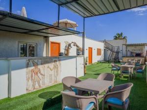 a patio with tables and chairs and a painting on the wall at khofo pyramids view in Cairo