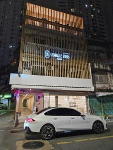 a white car parked in front of a building at Urban Pod Capsule Hostel in Bangkok