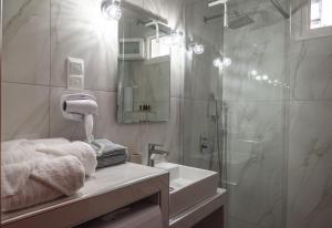 a bathroom with a shower and a sink and a mirror at To Spiti in Keramoti +11 photos
