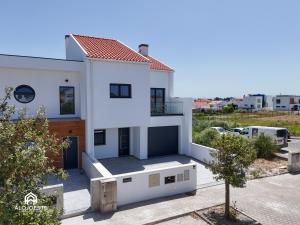 a white house with a view of a parking lot at Ondas do Oeste - 3 bedroom villa in Silveira