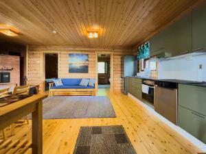 a kitchen and living room with a blue couch at Villa Hauki, Puruvesi Lakeside by Naaranlahti in Naaranlahti