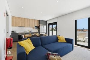 a living room with a blue couch and a kitchen at Ondas do Oeste - 3 bedroom villa in Silveira