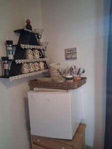 a kitchen with a shelf on top of a refrigerator at Skærbæk BB Bed and Bath in Skærbæk +3 photos