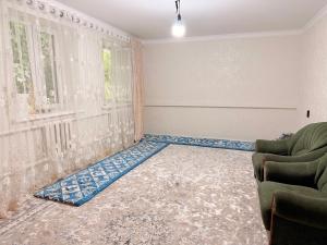 a living room with a couch and a window at Уютный дом GS in Kegeti