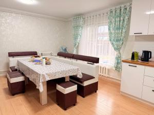 a dining room with a table and chairs and a kitchen at Уютный дом GS in Kegeti