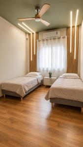 a bedroom with two beds and a ceiling fan at Limera View Monemvasia in Monemvasia