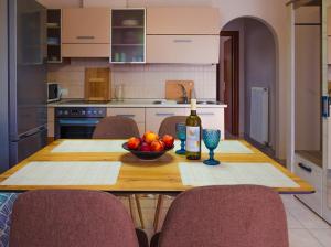a table with a bowl of fruit and a bottle of wine at To Spiti in Keramoti
