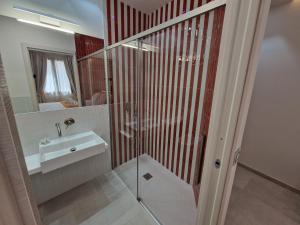 a bathroom with a glass shower and a sink at Acqua Marina Rooms in La Caletta