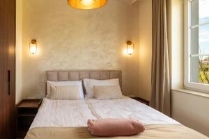 a bedroom with a bed with a pillow on it at Rezydencja De Rosse in Jastrzębia Góra