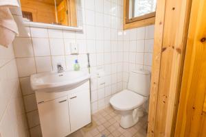 a small bathroom with a toilet and a sink at Villa Hauki, Puruvesi Lakeside by Naaranlahti in Naaranlahti
