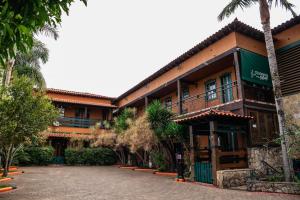 a building with a palm tree in front of it at Tiradentes Village in Tiradentes