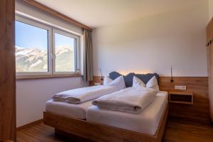 a bedroom with a bed with a large window at Gasthof Bergblick in Berwang