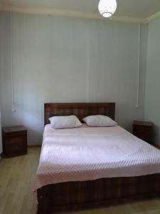 a bedroom with a large bed with two pillows at Motena Guesthouse in Martvili +16 photos